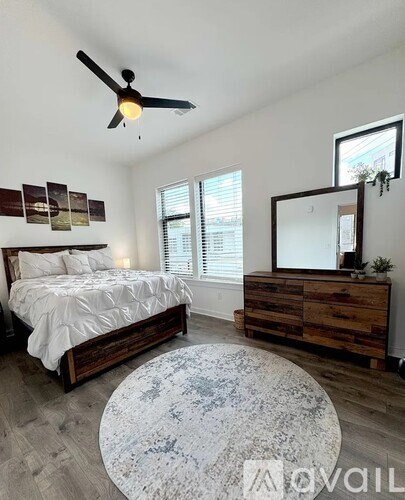 A bedroom with a bed, dresser, and mirror.