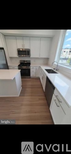 A kitchen with white cabinets and a wooden floor.
