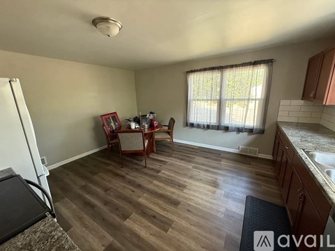 A kitchen with a dining table and chairs in the middle of the room.