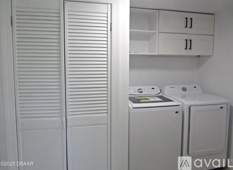 Closet with white clothes dryer and washer.