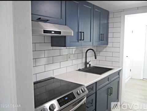 A kitchen with a black stove top oven and a black dishwasher.