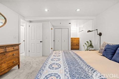 A bedroom with a bed, dresser, and mirror.