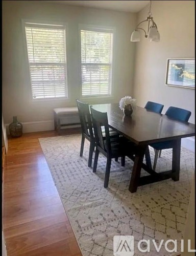 A dining room with a wooden table and chairs.