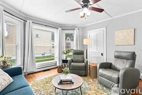A living room with a blue couch and a grey recliner.