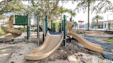 A playground with a slide and a green sign.
