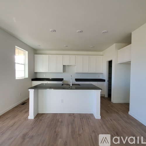 A kitchen with white cabinets and a black countertop.