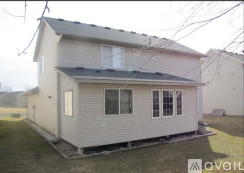 A house with a grey roof and white walls is for sale.