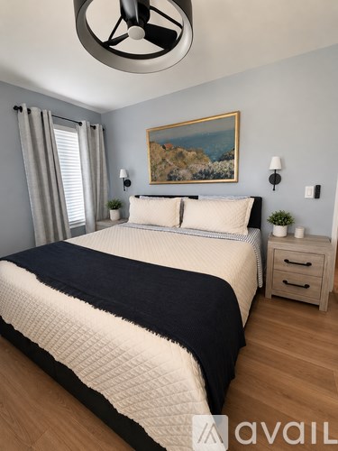 A bedroom with a large bed and a ceiling fan.