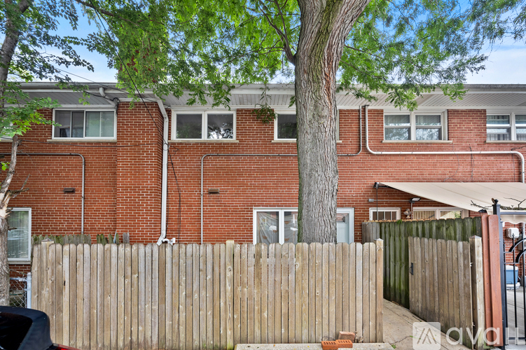 A red brick building with a wooden fence in front.