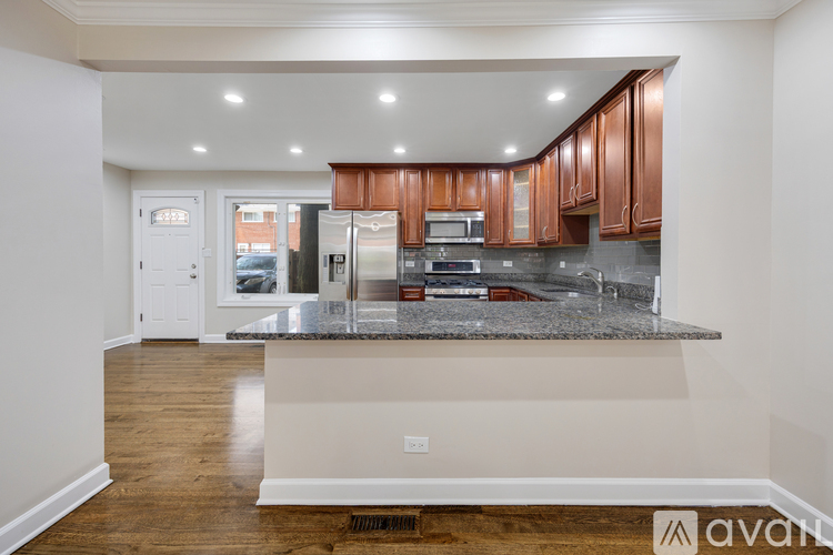 A kitchen with wooden cabinets and a granite countertop.