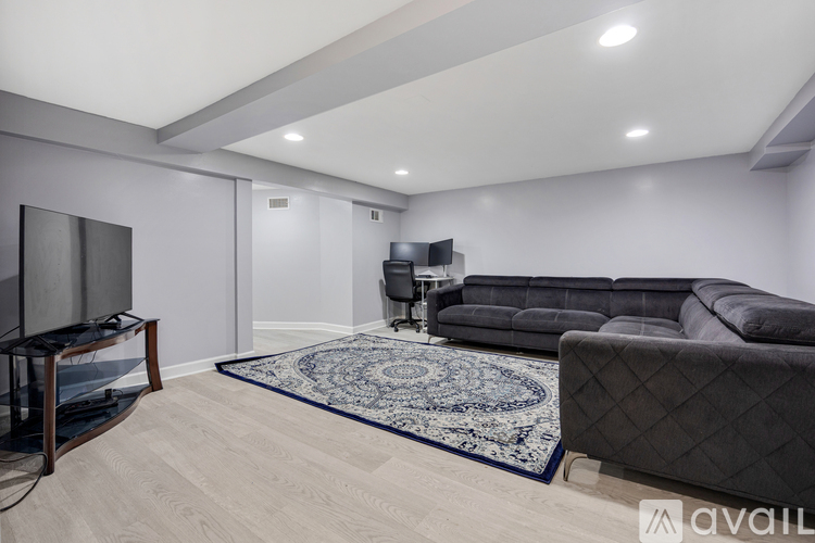 A living room with a black couch and a television.
