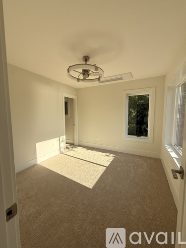 A room with a carpeted floor and a ceiling fan.