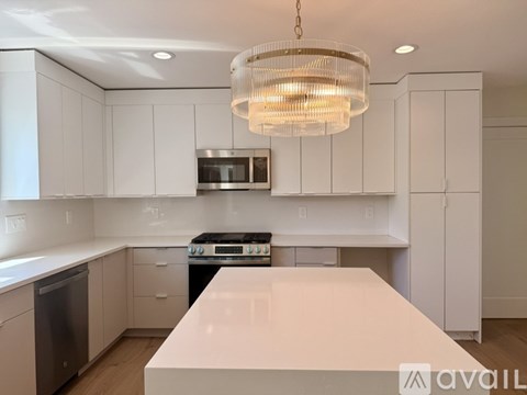 A modern kitchen with white cabinets and a large island.