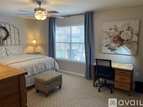 A bedroom with a bed, desk, and chair.