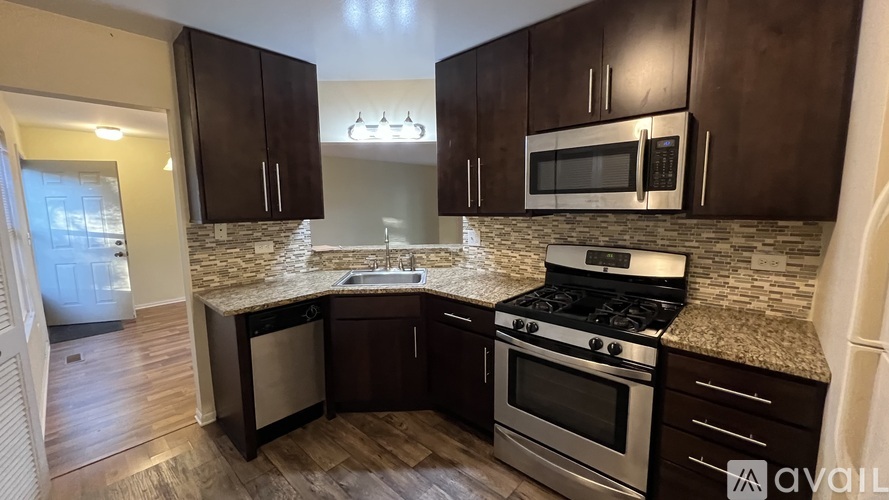 A kitchen with dark wood cabinets and stainless steel appliances.