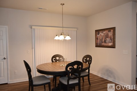 A dining room with a round table and chairs.