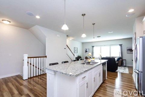 A kitchen with white cabinets and a granite countertop.