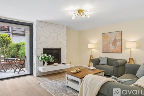 A living room with a fireplace and a painting on the wall.