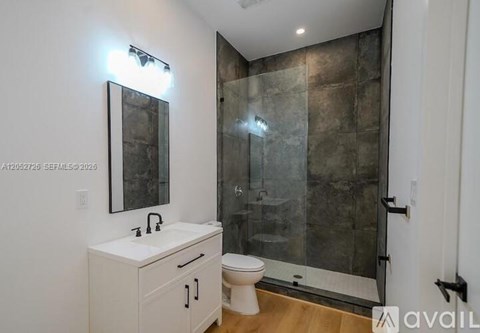 A bathroom with a toilet, sink, and walk-in shower.