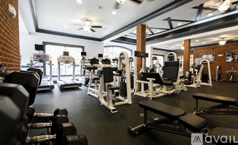 A gym with various exercise equipment and a brick wall.