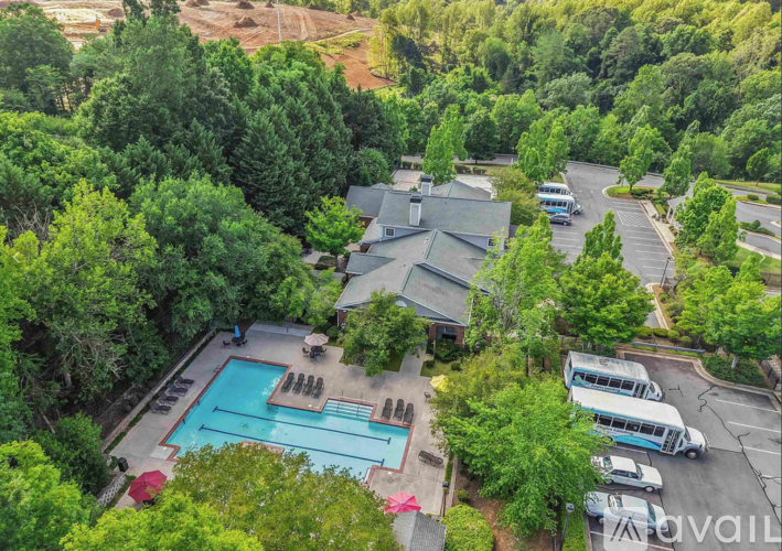 A bird's eye view of a resort with a swimming pool and a parking lot.