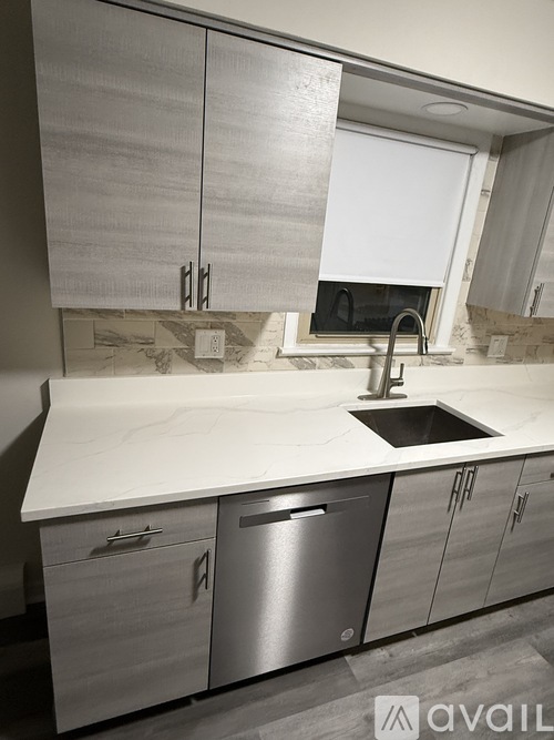 A kitchen with a white countertop and a stainless steel dishwasher.
