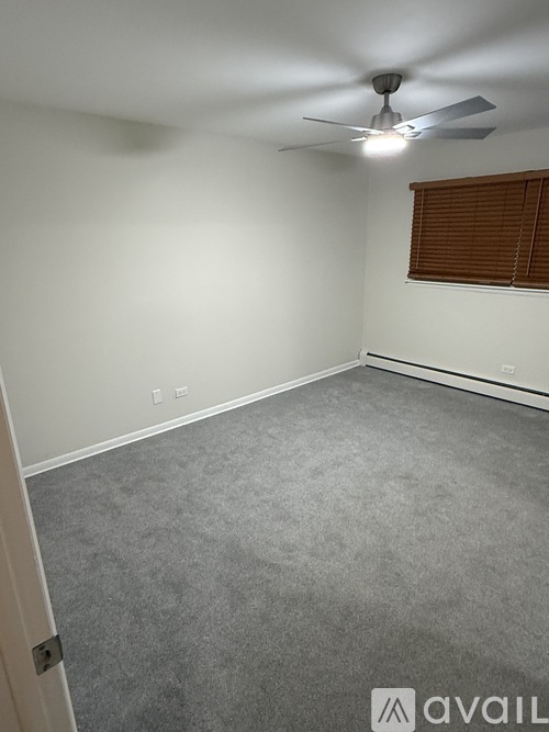 A room with a ceiling fan and carpeted floor.