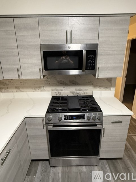 A modern kitchen with a stainless steel oven and microwave above a stove.