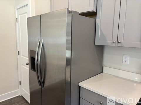A stainless steel refrigerator with two doors is in a kitchen.