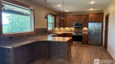 A kitchen with wooden cabinets and a stone backsplash.