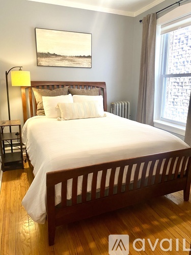 A bedroom with a large bed and a painting on the wall.