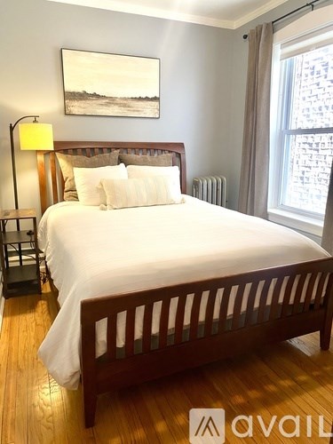 A bedroom with a large bed and a painting on the wall.