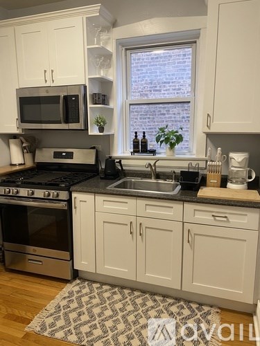 A kitchen with white cabinets and a black stove top oven.