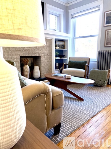 A living room with a tan couch and a fireplace.