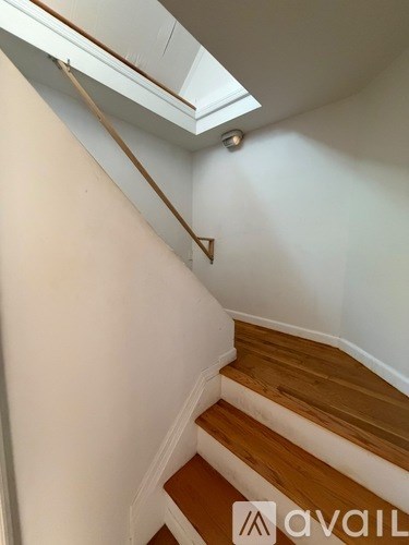 A staircase with wooden steps and a white wall.