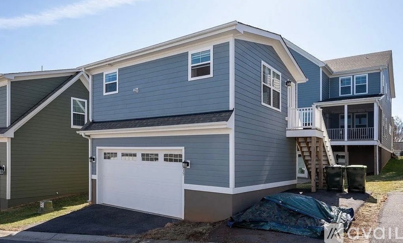 A two-story house with a garage and a balcony on the upper floor.