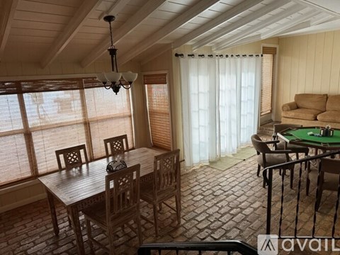 A room with a table and chairs and a pool table.