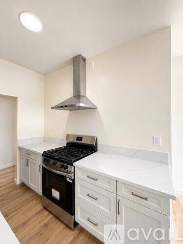 A kitchen with a stove top oven and a range hood.