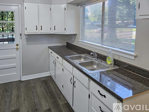 A kitchen with white cabinets and a granite countertop.