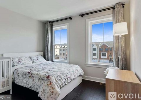 A bedroom with a large bed and a window overlooking a residential area.