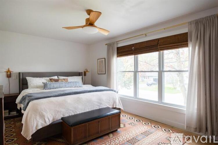 A bedroom with a large bed and a ceiling fan.