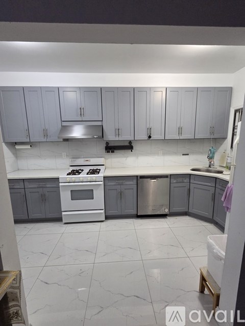 A kitchen with white appliances and grey cabinets.