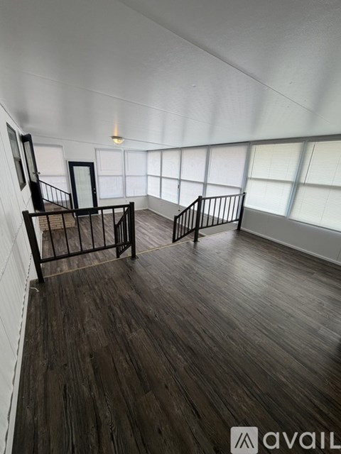 A room with wooden floors and a staircase.