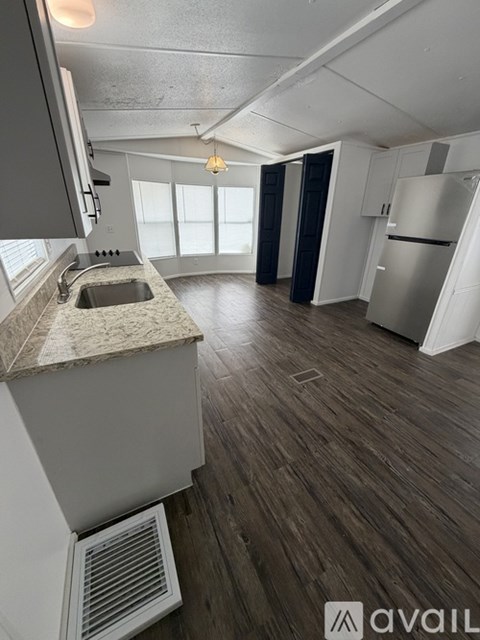 A kitchen with a sink and a refrigerator.