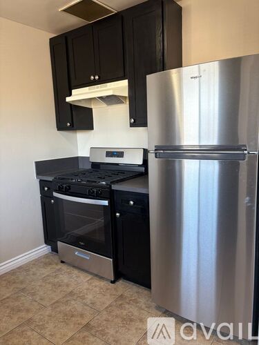 A kitchen with a stainless steel refrigerator and a stove with an oven.