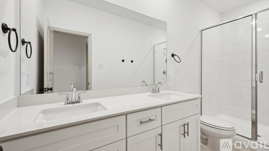 A bathroom with a sink, mirror, toilet and shower.