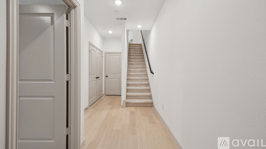 A hallway with a staircase leading to the second floor.