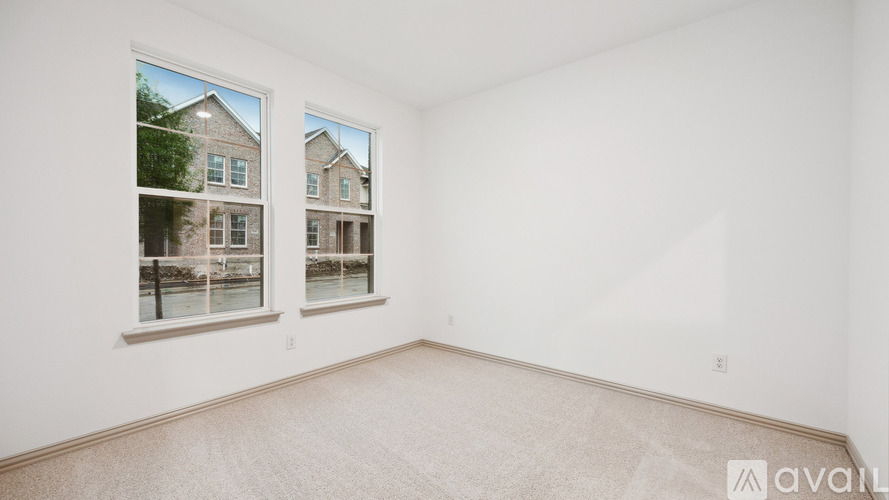A room with a large window showing a view of a building across the street.