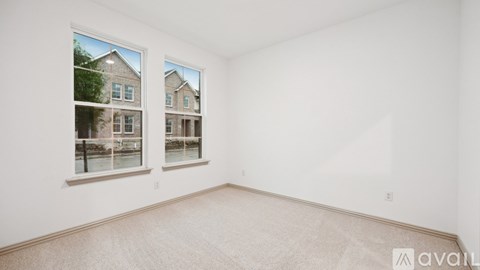 A room with a large window showing a view of a building across the street.