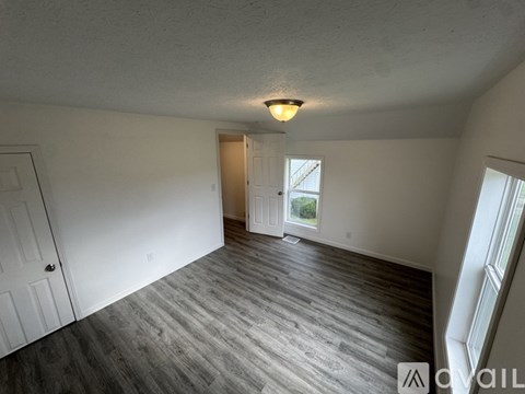 A room with a wooden floor and a ceiling light.